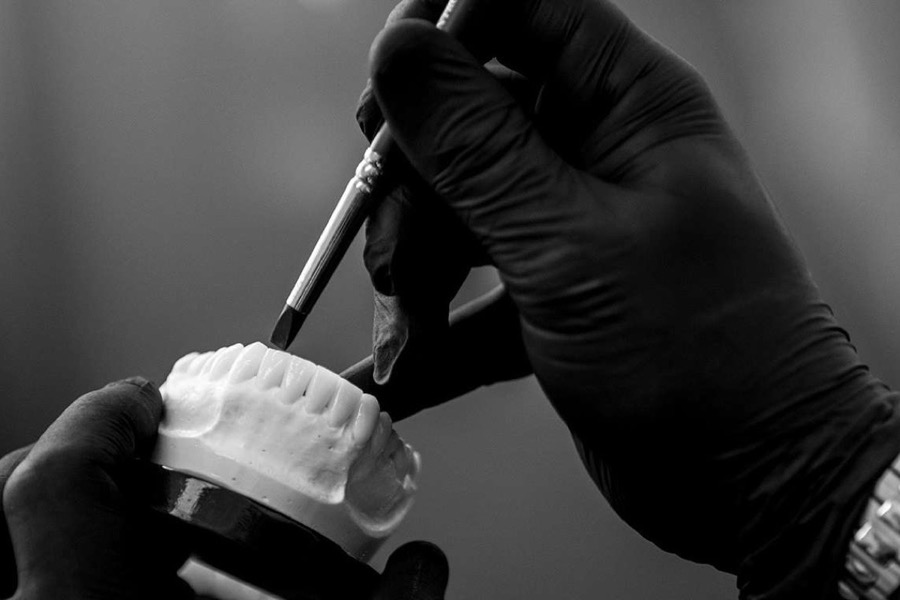 Un odontotecnico rifinisce a mano una protesi